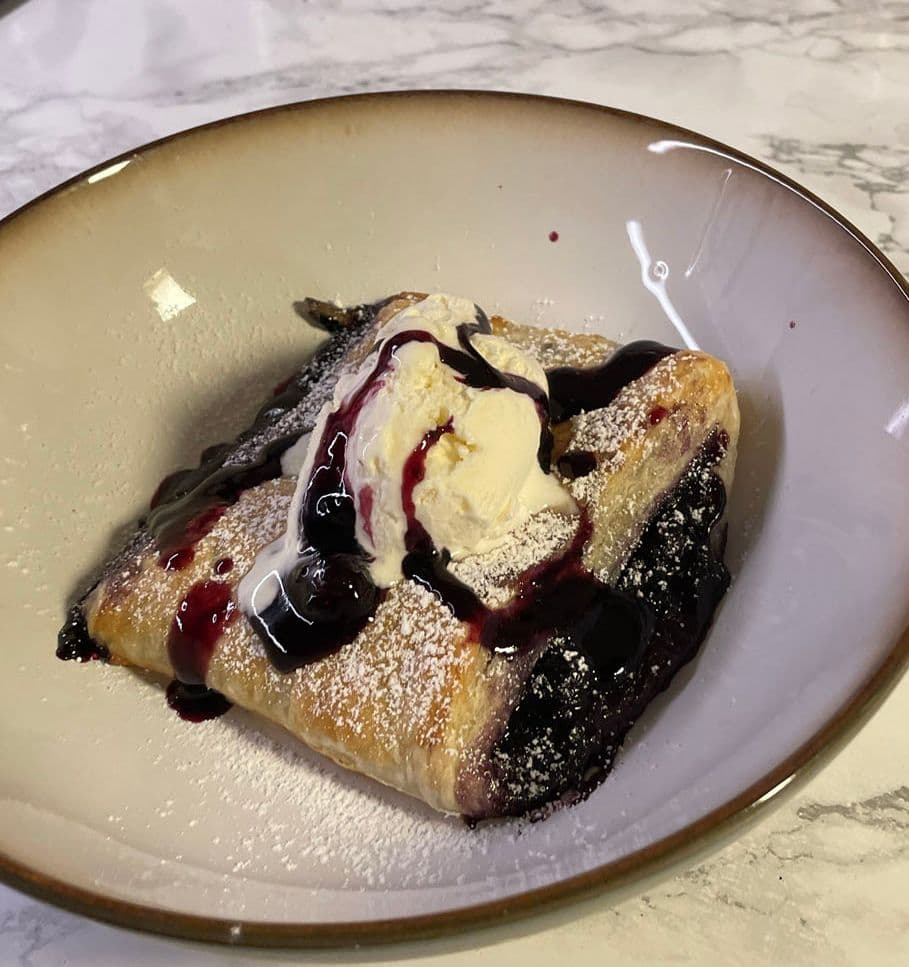 Smördegspaj med blåbär serverat med glass